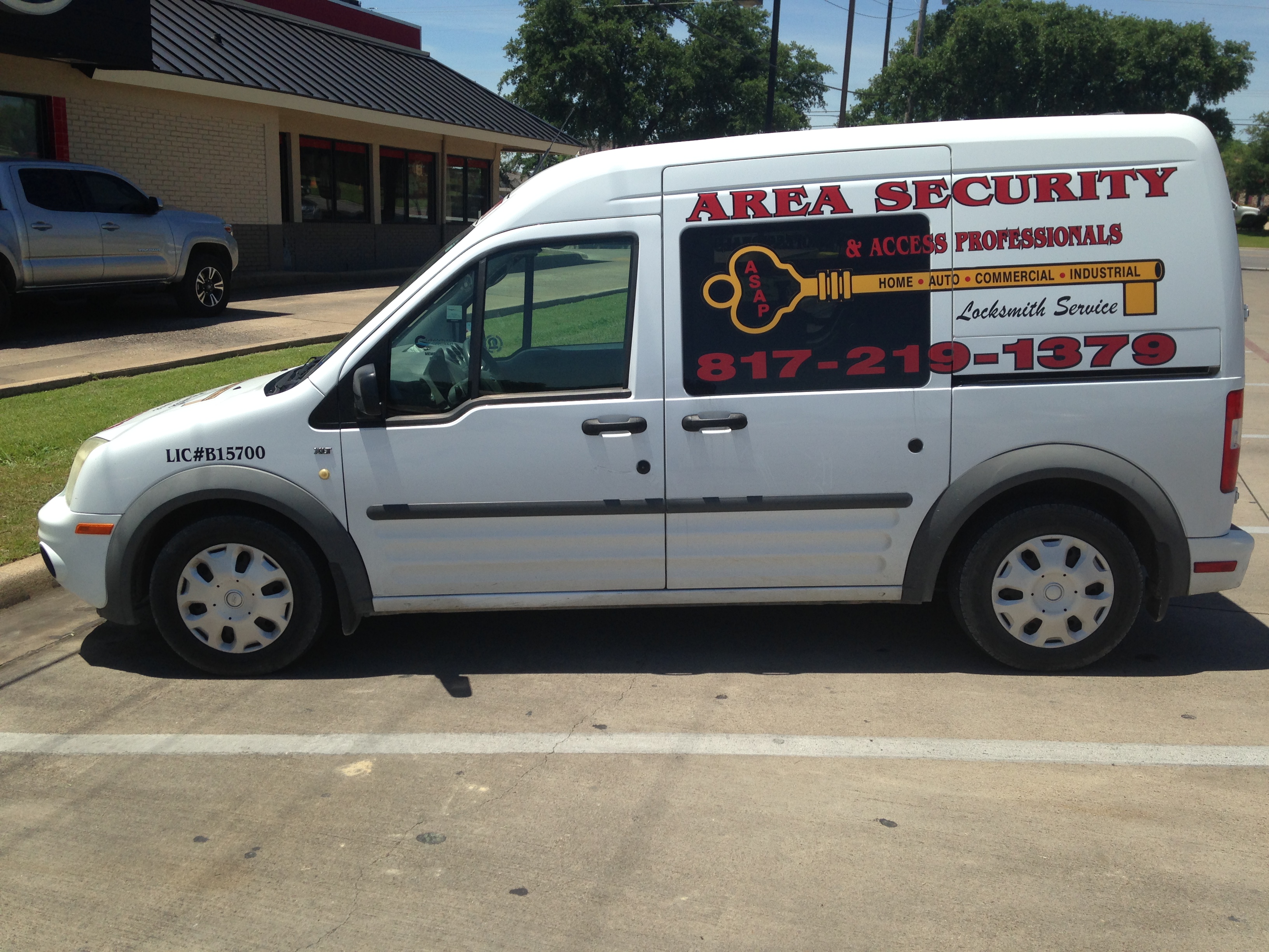 Area Security & Access Professionals Locksmith LLC service van, showing Texas locksmith license number B15700 and the 817-219-1379 phone number, parked at a job site near Granbury, TX